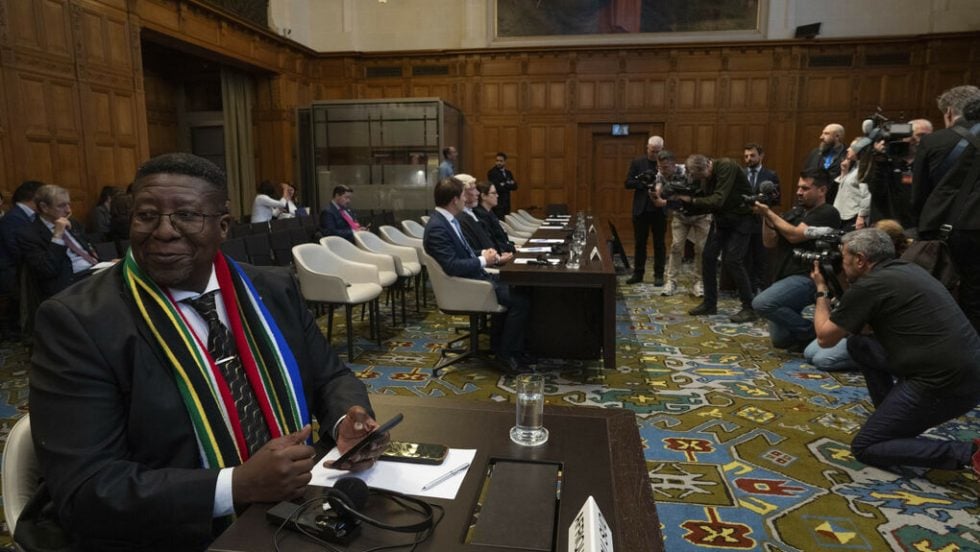 Χθεσινό στιγμιότυπο από το Διεθνές Δικαστήριο της Χάγης. Σε πρώτο πλάνο ο πρέσβης της Νότιας Αφρικής στην Ολλανδία, Β. Μαντονσέλα, και στο βάθος η νομική ομάδα του Ισραήλ που έχει συγκεντρώσει το ενδιαφέρον των φωτογράφων λίγο πριν από την είσοδο των δικαστών στην αίθουσα
